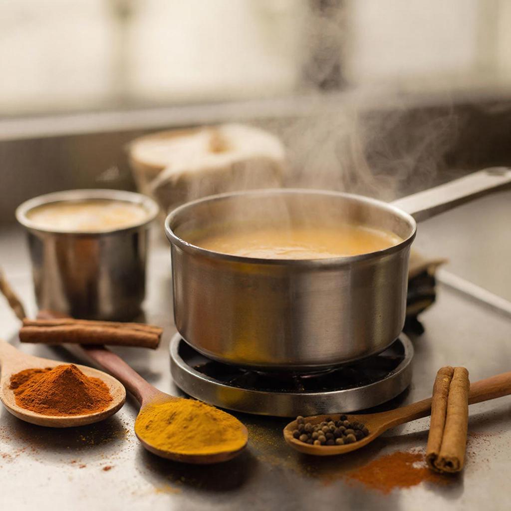 Приготовление латте с карри Приготовление латте с карри на плите с куркумой, корицей и имбирем
