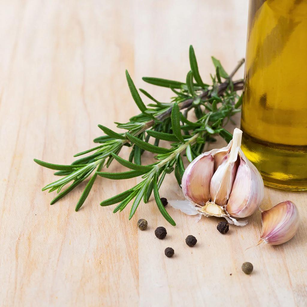 Подготовка ингредиентов Веточка розмарина, чеснок и оливковое масло для домашней заготовки
