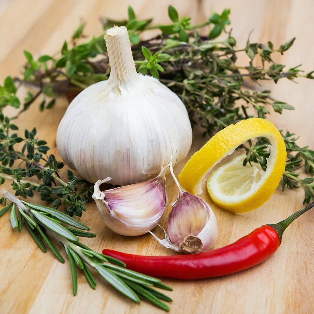 Подготовка ингредиентов для масла Чеснок, лимонная цедра, чили и сушеные травы для ароматного масла