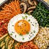 Готовый бибимбап с овощами, яйцом, кимчи и соусом кочхуджан